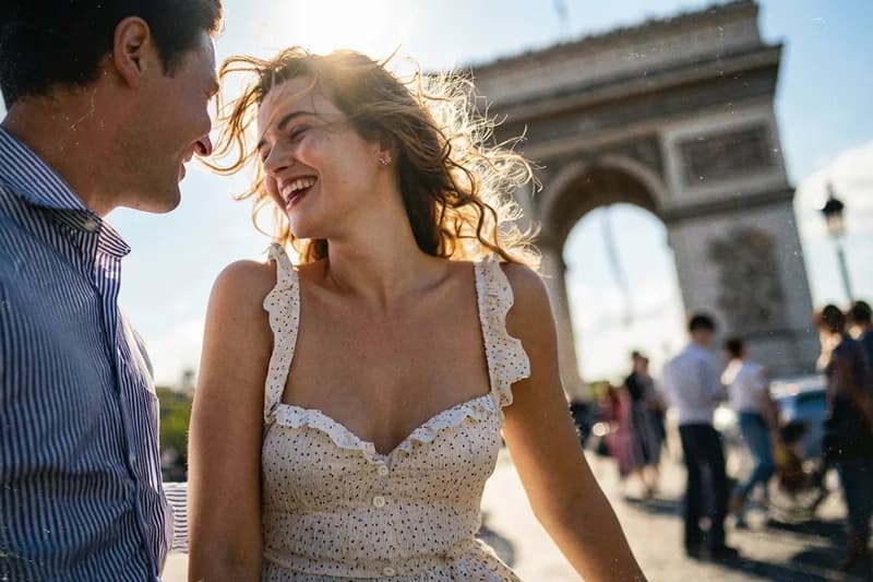 Pareja de recién casados feliz disfrutando su Luna de Miel en el Arco del Triunfo, París, gracias a su lista de regalos en dinero de Invitalo.cl