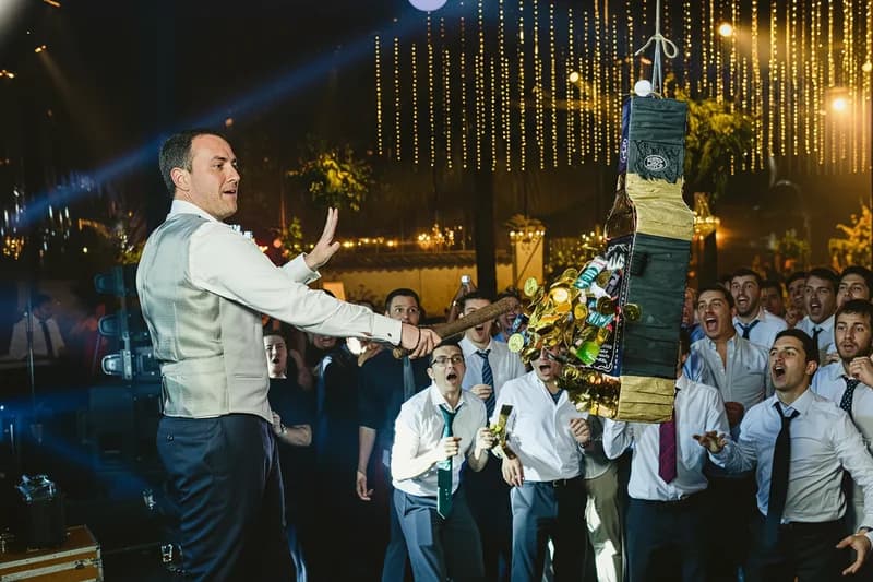 Invitados participando en una piñata para adultos durante la fiesta de un matrimonio en Chile, como parte de una experiencia interactiva.